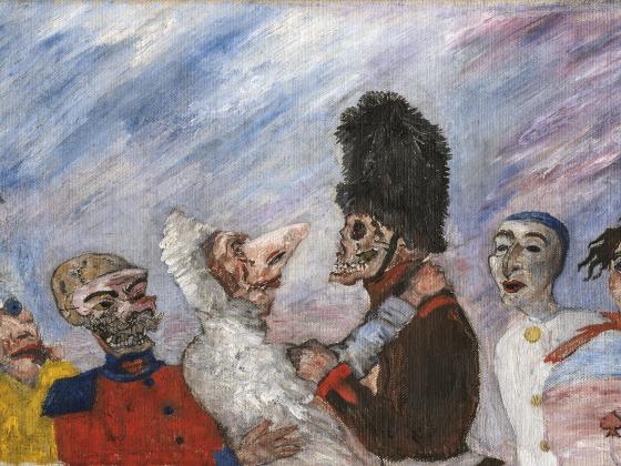 Sieben maskierte Personen, von denen man nur die obere Körperhälfte sieht, stehen vor einem blau-weißen Hintergrund. 