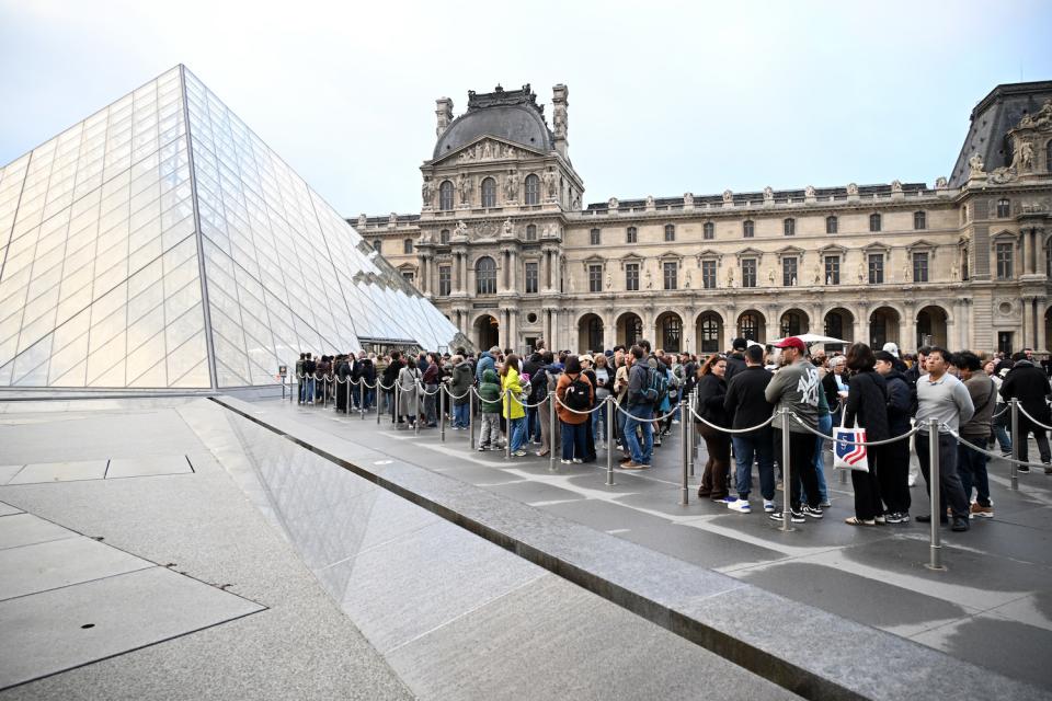 Menschen stehen am Montag im Hof der Louvre-Pyramide Schlange, kurz bevor bekannt gegeben wird, dass das Museum den zweiten Tag in Folge geschlossen bleibt